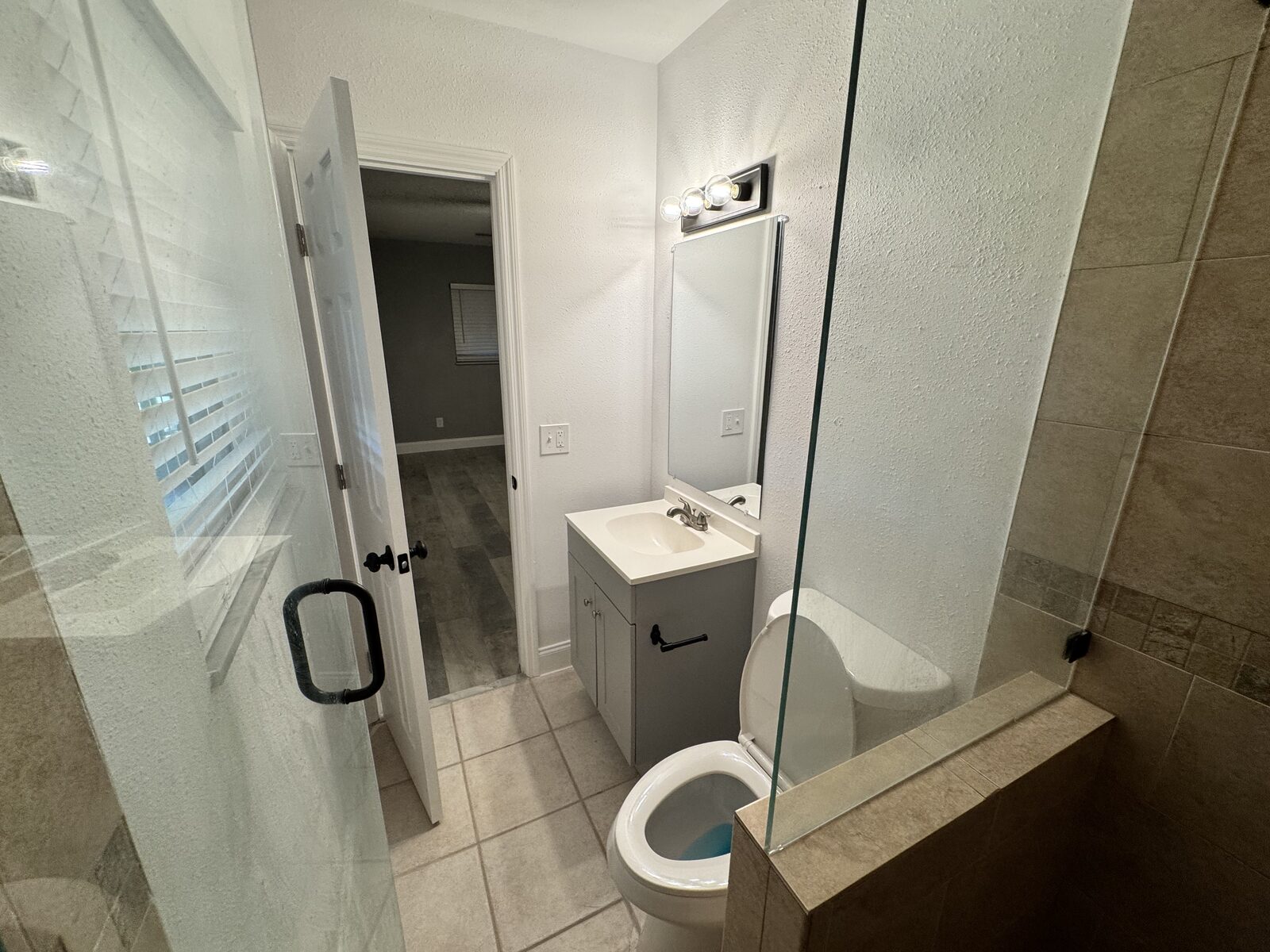 Second bathroom with glass shower enclosure and updated vanity