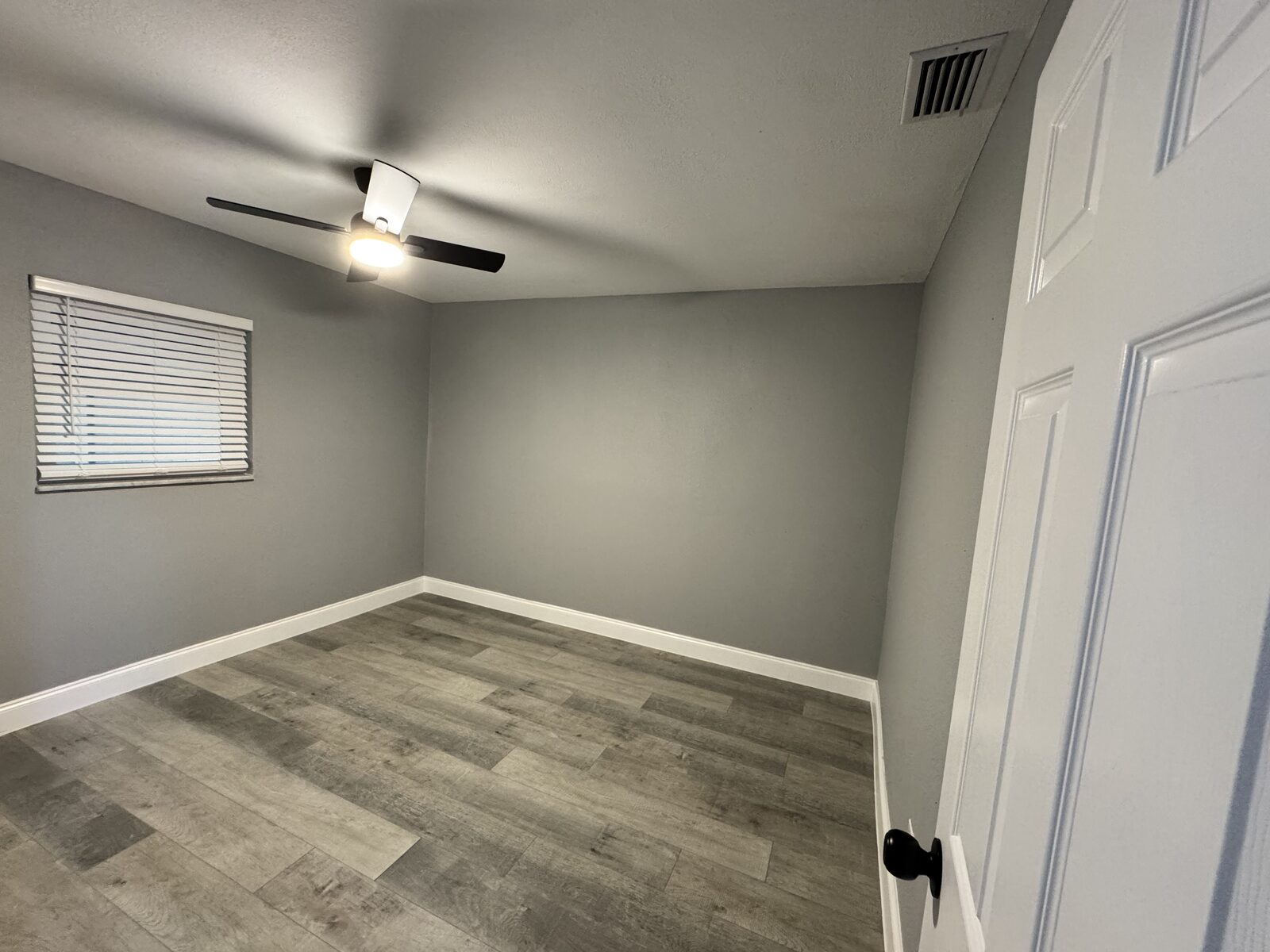 Bedroom with ceiling fan and light gray walls