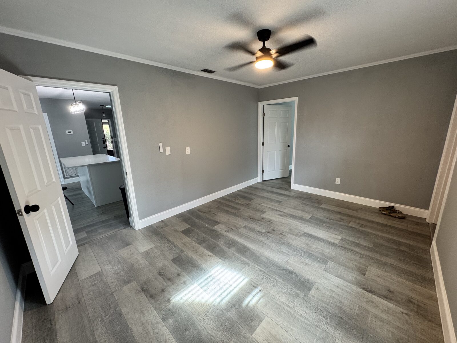 Living space with ceiling fan and new wood-look plank flooring